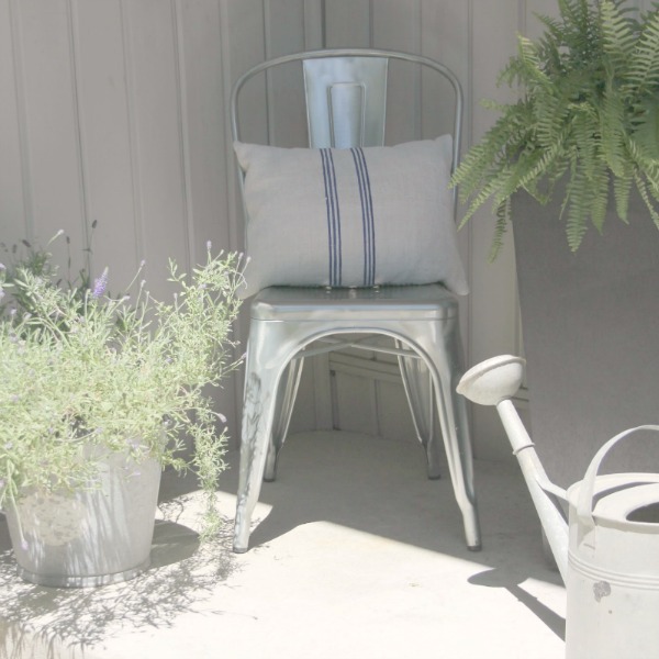 French Tolix style chair with grainsack pillow and farmhouse galvanized buckets on my front porch - Hello Lovely Studio.