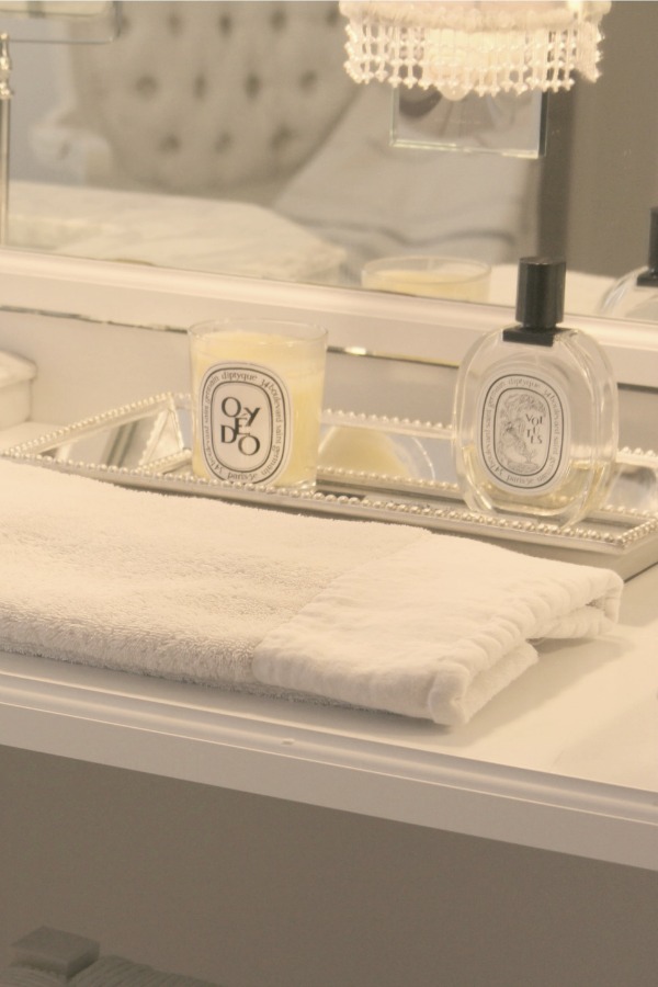 Mirrored tray with Diptyque essentials in our bathroom - Hello Lovely Studio. Come discover more inspiring trays for layering and vignettes in Adding Tray Très Chic to Your Home.