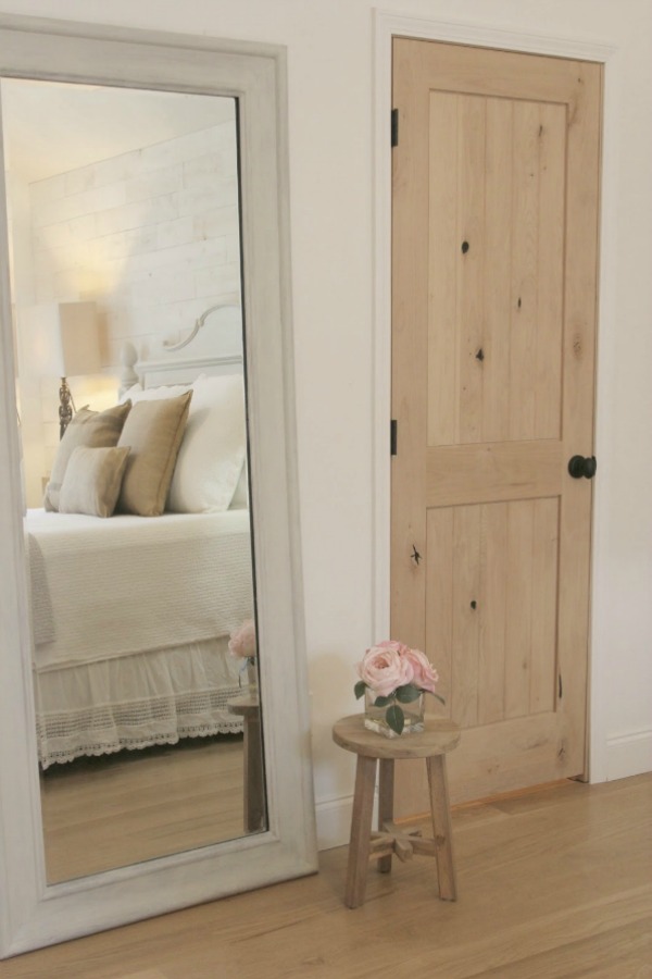 French Nordic style and French farmhouse decor in a rustic cottage bedroom by Hello Lovely Studio with alder door, white oak flooring, and white linens. White paint color is Benjamin Moore White. French Farmhouse Decor & Lightening Up for Spring.