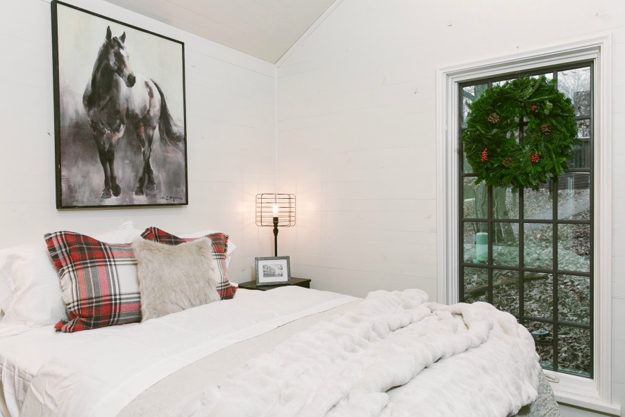 Bedroom with elegant floor to ceiling window in tiny house designed by Jeffrey Dungan, an exquisitely crafted luxurious Low Country style Designer Cottage at The Retreat at Oakstone.