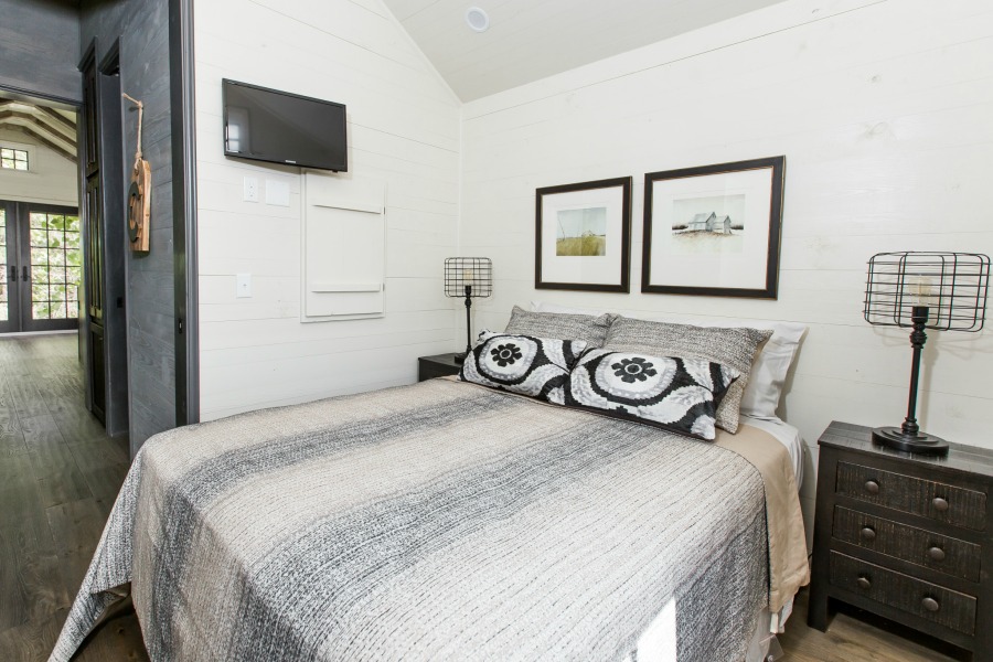 Bedroom with shiplap in tiny house designed by Jeffrey Dungan, an exquisitely crafted luxurious Low Country style Designer Cottage at The Retreat at Oakstone.