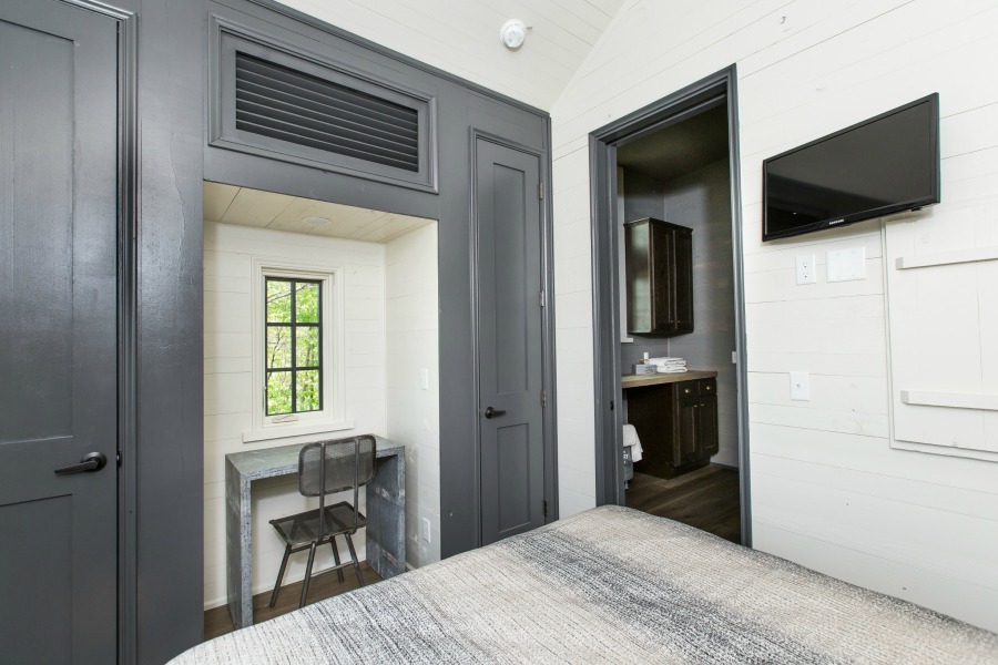 Built-in desk area flanked by closets in bedroom of tiny house designed by Jeffrey Dungan, an exquisitely crafted luxurious Low Country style Designer Cottage at The Retreat at Oakstone.