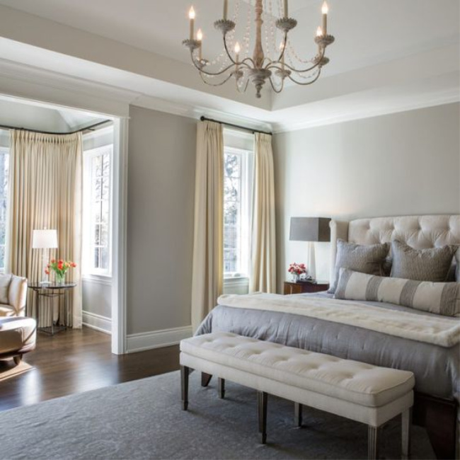 Benjamin Moore Revere Pewter in a luxurious French country bedroom with tufted headboard and bench. #paintcolors #reverepewter #benjaminmoore #bedroom #bestwhitepaint