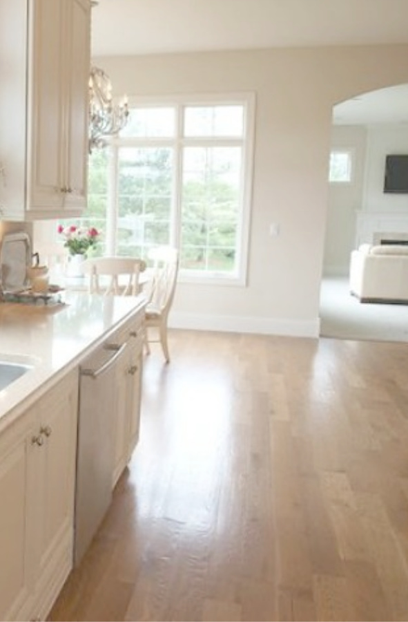 Benjamin Moore White Sand paint color in serene monochromatic French country kitchen - Hello Lovely Studio. #paintcolors #benjaminmoore #whitesand #whitepaintcolors #warmwhitepaints