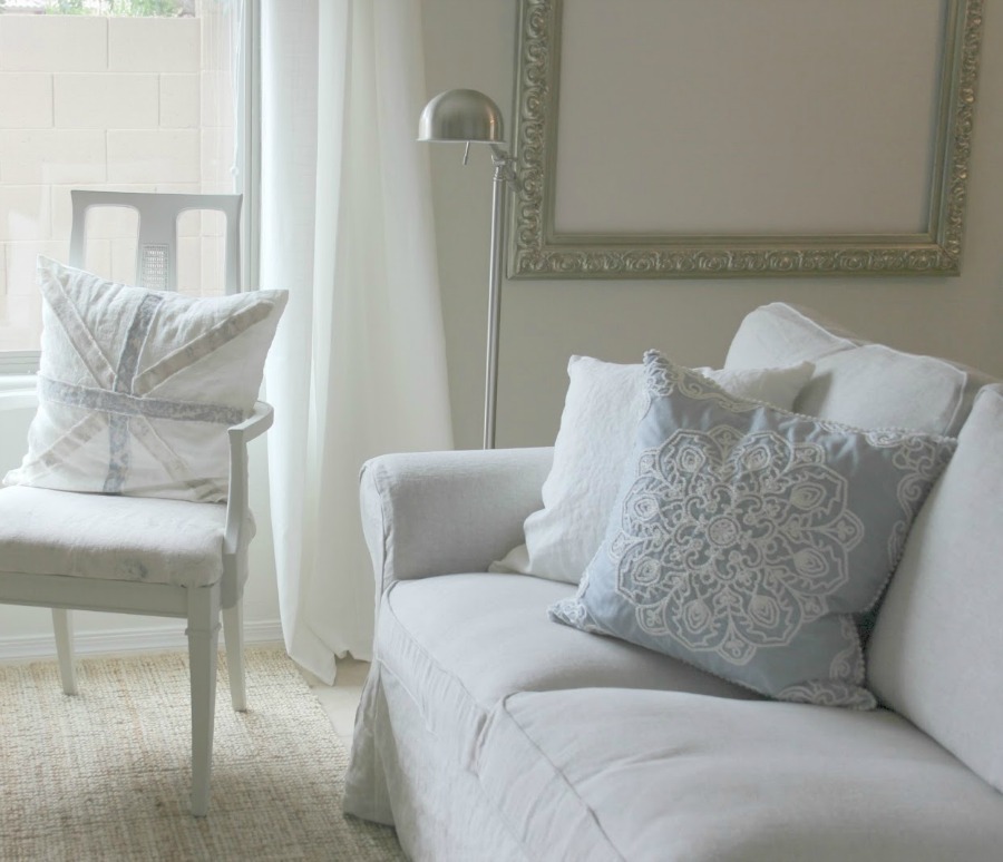 Serene white living room with pale blue accents features Ektorp sofa (Ikea) with custom Bemz slipcover in Belgian linen - Hello Lovely Studio. #livingroom #slipcoveredsofa #bemz