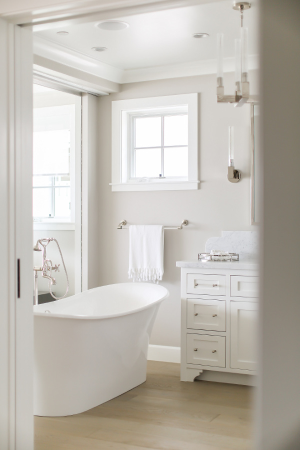 Collonade Gray by Sherwin Williams is the paint color on walls of this glorious and serene bathroom by Melissa Morgan Design. #paintcolors #collonadegray #sherwinwilliams #paintcolors