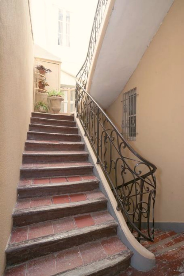 Staircase with tile and wrought iron rail. Classic French apartment with luxurious interiors has been fully renovated to high standards in Carcassonne, France and is available to rent - L'ancienne Tannerie.