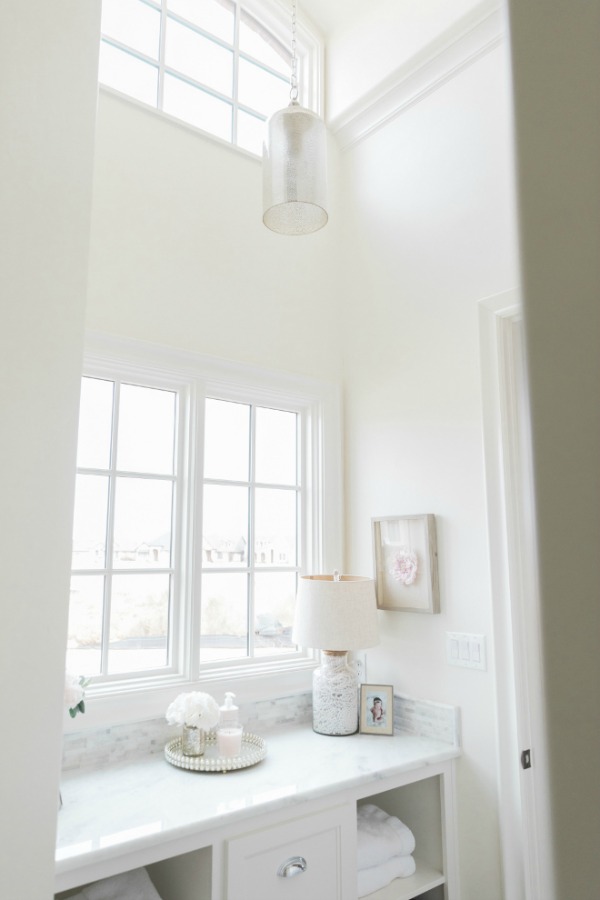 Elegant French country white bathroom with Sherwin Williams Alabaster paint on walls. Brit Jones Design.