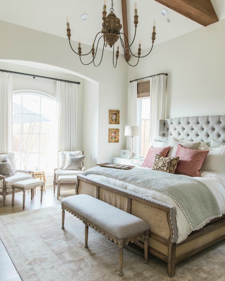 French country farmhouse white bedroom with tufted headboard and arch window bay. Sherwin Williams Alabaster paint color on walls. Brit Jones Design.