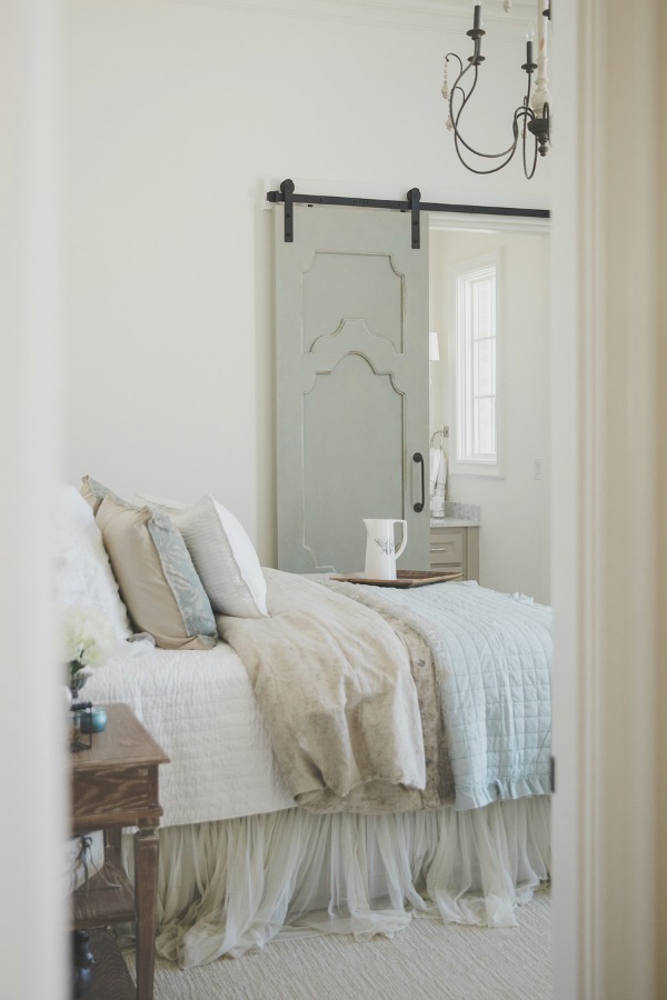 French country farmhouse pale blue and white bedroom with Duck Egg blue barn door. Sherwin Williams Alabaster paint color on walls. Brit Jones Design. #bedroompaintcolors #sherwinwilliamsalabaster #frenchcountrydecor