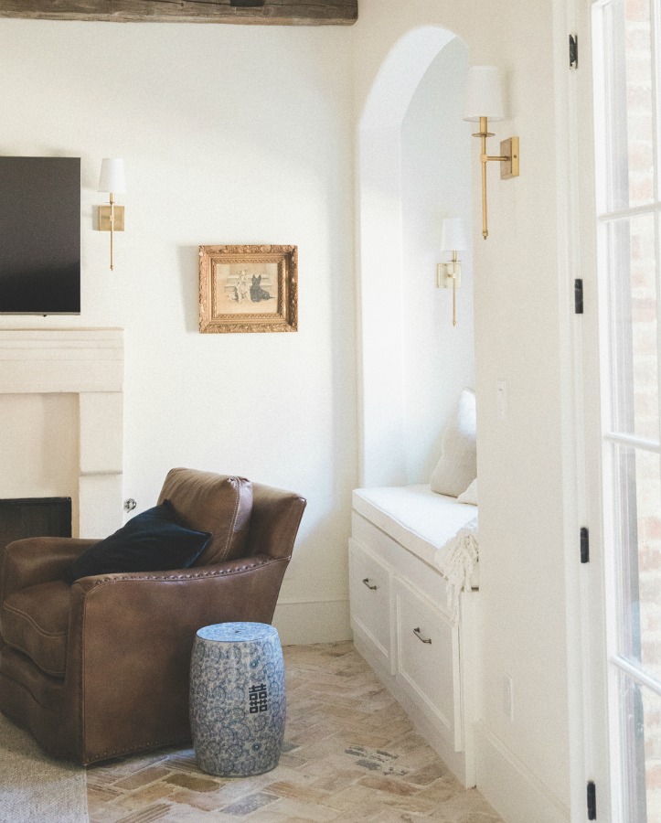 Cozy den with window seat nook and leather chair in a French country farmhouse by Brit Jones Design.