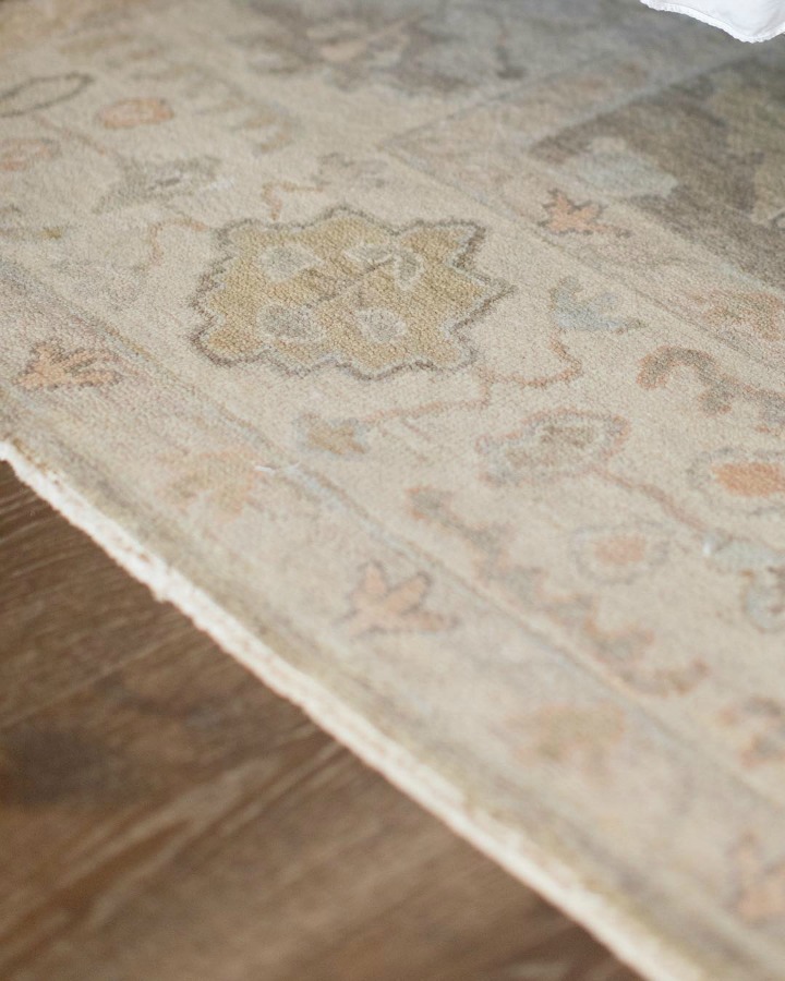 Detail of pale pastel pattern rug runner in French country farmhouse kitchen with wood floors. Brit Jones Design.