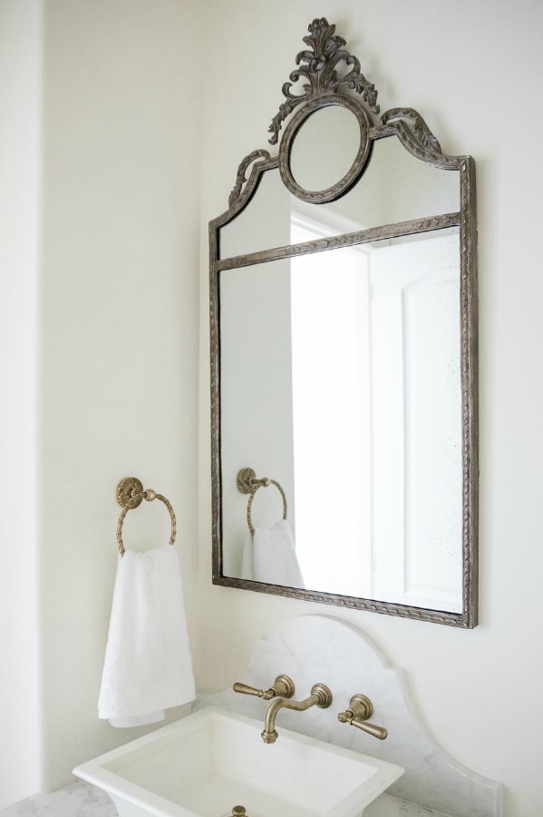 Sherwin Williams Alabaster paint color on walls of French country powder room with vessel sink and elegant mirror. Brit Jones Design.