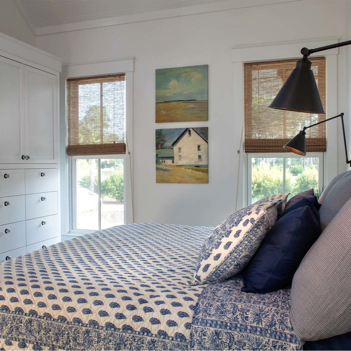 Coastal bedroom with blue paisley bedding, built-ins, and black swing arm task sconces - Lisa Furey. #coastalstyle #bedroomdesign #blueandwhite #coastalbedroom #interiordesign #cottagestyle