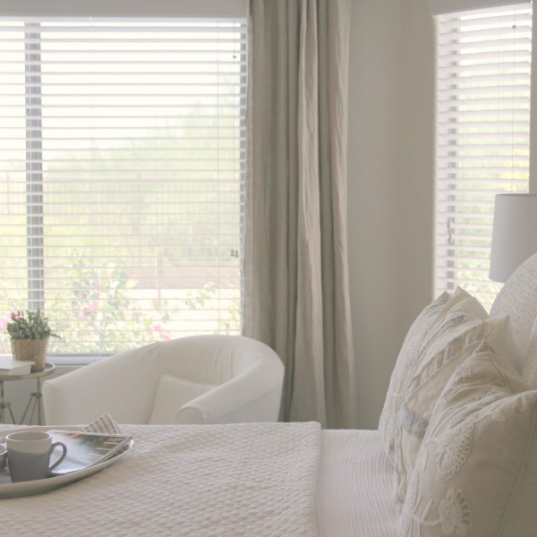 Serene and sunny white bedroom in Arizona with board and batten panel wall and sliding modern barn door. Hello Lovely Studio.