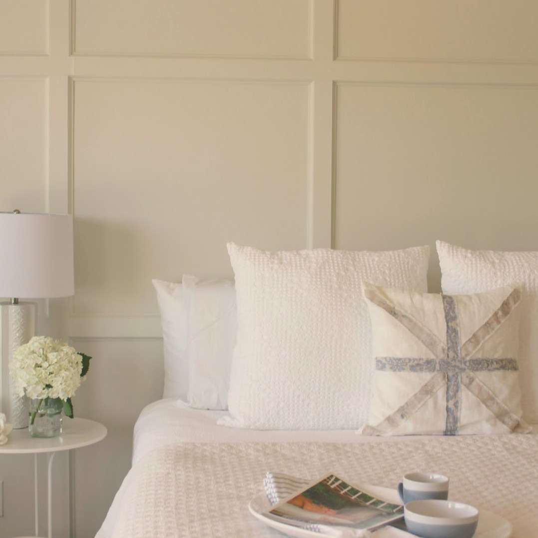 Serene and sunny white bedroom in Arizona with board and batten panel wall and sliding modern barn door. Hello Lovely Studio.