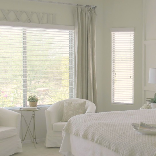 Serene and sunny white bedroom in Arizona with board and batten panel wall and sliding modern barn door. Hello Lovely Studio.