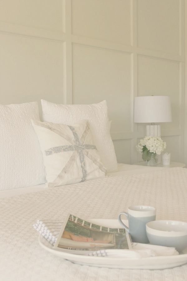 Serene and sunny white bedroom in Arizona with board and batten panel wall and sliding modern barn door. Hello Lovely Studio.