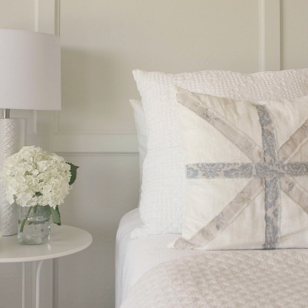 Serene and sunny white bedroom in Arizona with board and batten panel wall and sliding modern barn door. Hello Lovely Studio.