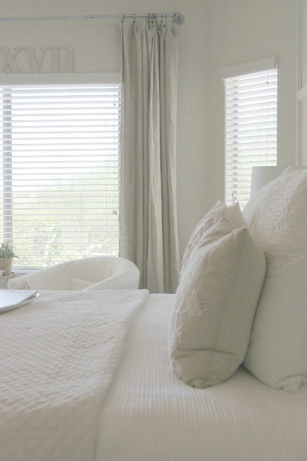 Serene and sunny white bedroom in Arizona with board and batten panel wall and sliding modern barn door. Hello Lovely Studio.