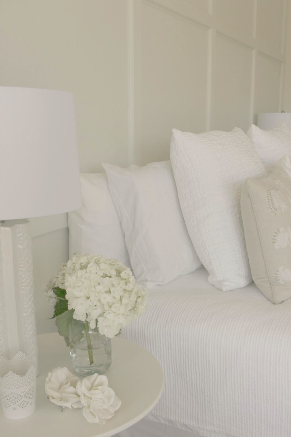 Serene and sunny white bedroom in Arizona with board and batten panel wall and sliding modern barn door. Hello Lovely Studio.