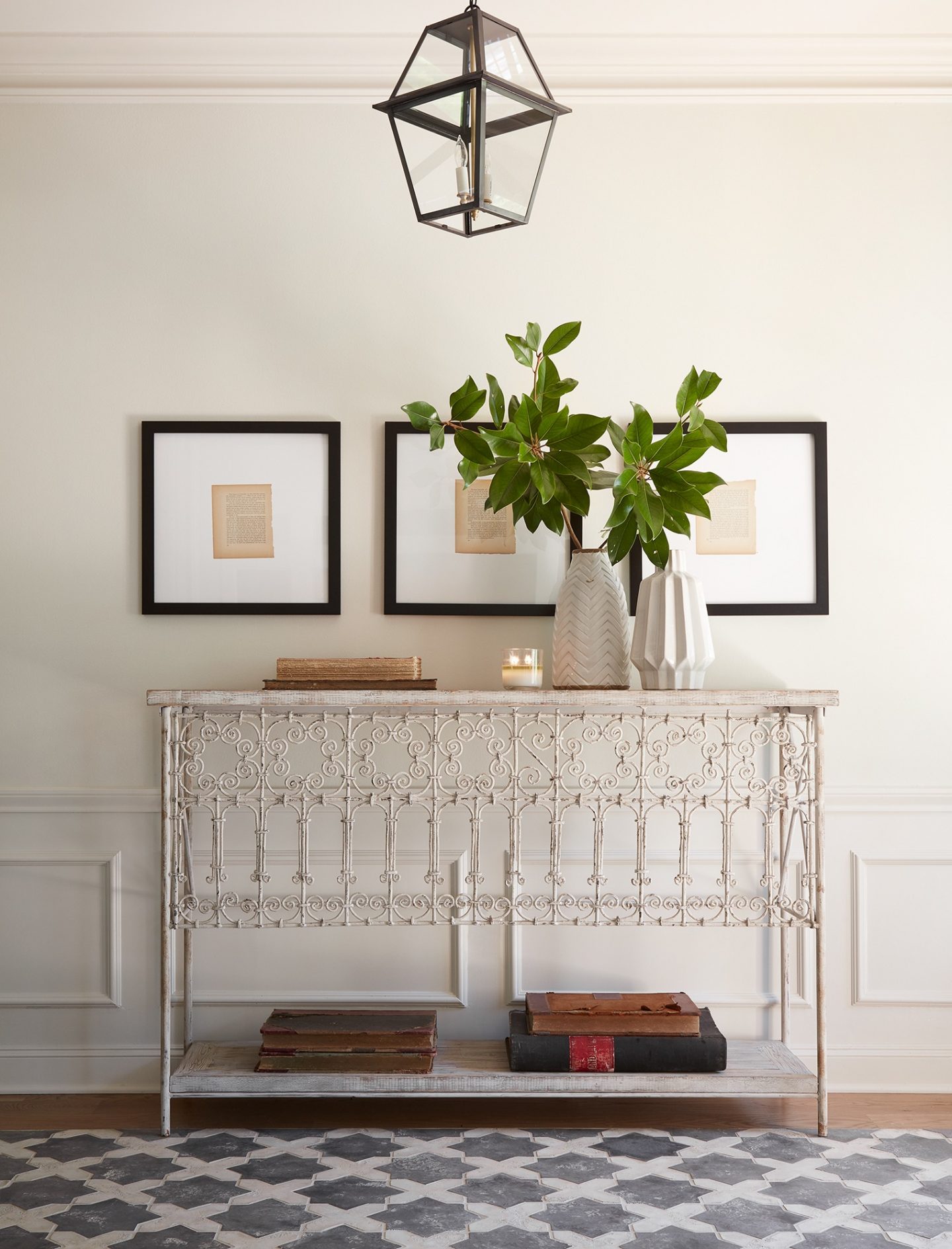 Gorgeous foyer in HGTV Fixer Upper's THE CLUB HOUSE episode! A vintage metal console table with delicate scrolling and encaustic tile rug in the white oak flooring. #fixerupper #theclubhouse #entryway #frenchfarmhouse #interiordesign #vintagestyle #consoletable