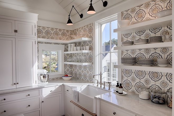 Classic white coastal cottage kitchen in Palmetto Bluff by Lisa Furey. Modern farmhouse design elements include floating shelves, shiplap, white oak flooring, and apron front farm sink.