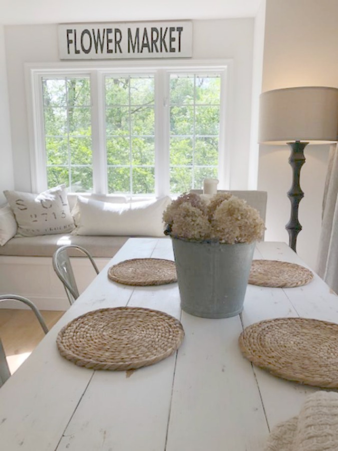 Serene tranquil white kitchen with farm sink, marble subway tile, Viatera Minuet quartz counters, white Shaker cabinets, and white oak flooring. Design and photo: Hello Lovely Studio. #kitchendesign #whitekitchen #minuet #whitequartz #benjaminmoorewhite