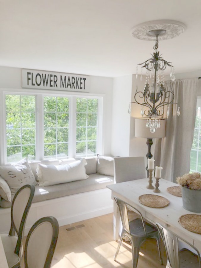 Serene tranquil white kitchen with farm sink, marble subway tile, Viatera Minuet quartz counters, white Shaker cabinets, and white oak flooring. See more Gorgeous European Country Interior Design Inspiration on Hello Lovely. #europeancountry #frenchfarmhouse #interiordesign