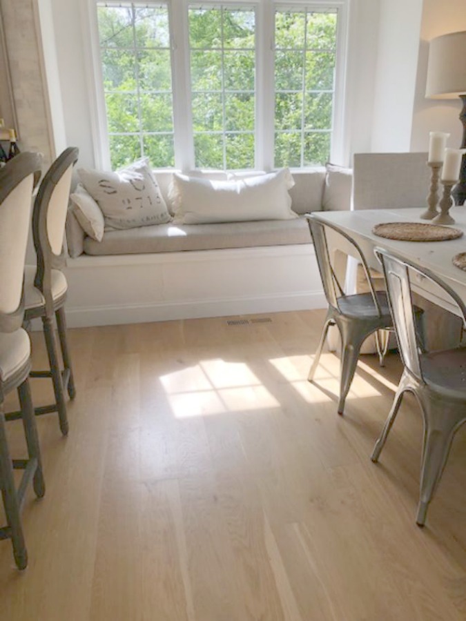 Serene tranquil white kitchen with farm sink, marble subway tile, Viatera Minuet quartz counters, white Shaker cabinets, and white oak flooring. Design and photo: Hello Lovely Studio. #kitchendesign #whitekitchen #minuet #whitequartz #benjaminmoorewhite