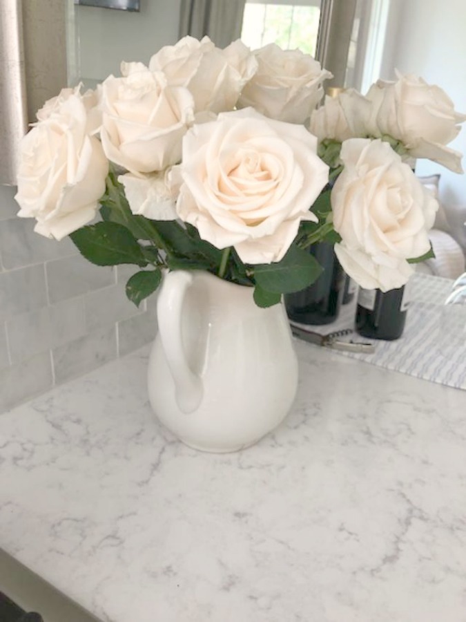 White glacier roses in vintage ironstone pitcher on Viatera Minuet quartz countertop in my kitchen - Hello Lovely Studio.