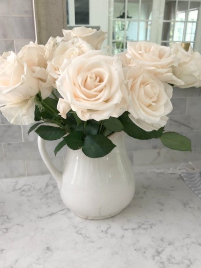 White glacier roses in ironstone pitcher on counter (Viatera Minuet quartz) - Hello Lovely Studio.