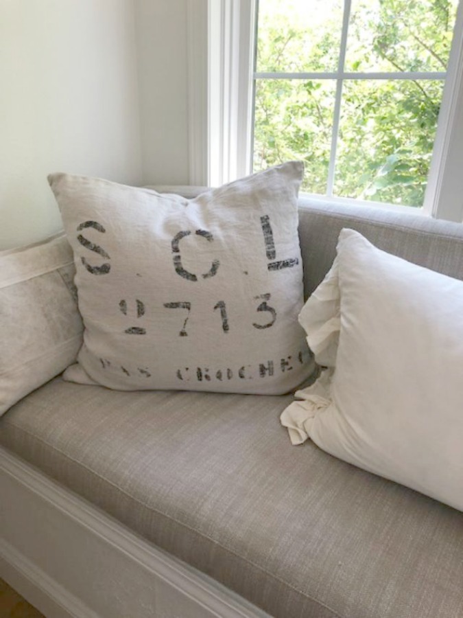 Detail of linen cushion window seat in my serene European inspired white kitchen - Hello Lovely Studio. See more Gorgeous European Country Interior Design Inspiration on Hello Lovely. #europeancountry #frenchfarmhouse #interiordesign