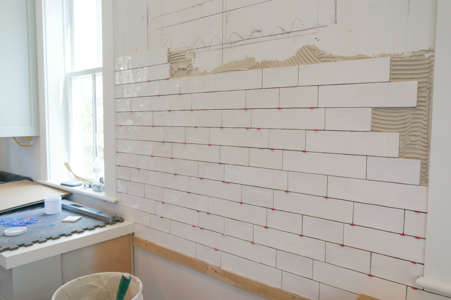 Elegant white farmhouse kitchen with Benjamin Moore Repose Grey cabinets, subway tile, gold accents, and reclaimed barn wood. Design: Finding Lovely. Wall color: Benjamin Moore Chantilly Lace.