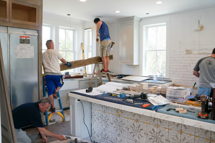 Elegant white farmhouse kitchen with Benjamin Moore Repose Grey cabinets, subway tile, gold accents, and reclaimed barn wood. Design: Finding Lovely. Wall color: Benjamin Moore Chantilly Lace.