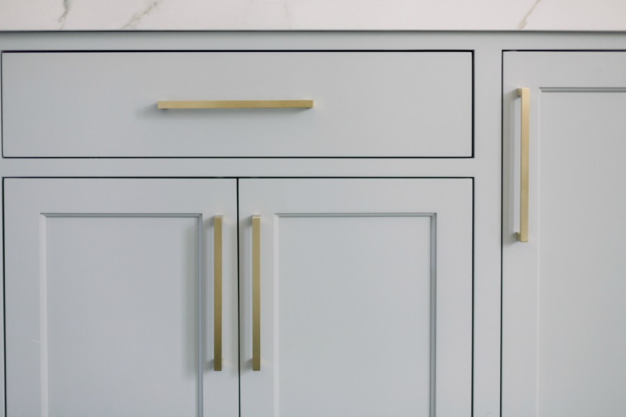 Elegant white farmhouse kitchen with Benjamin Moore Repose Grey cabinets, subway tile, gold accents, and reclaimed barn wood. Design: Finding Lovely. Wall color: Benjamin Moore Chantilly Lace.