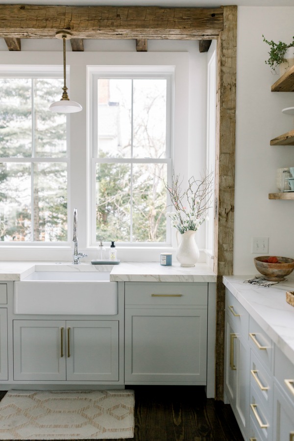 Elegant white farmhouse kitchen with Benjamin Moore Repose Grey cabinets, subway tile, gold accents, and reclaimed barn wood. Design: Finding Lovely. Wall color: Benjamin Moore Chantilly Lace.