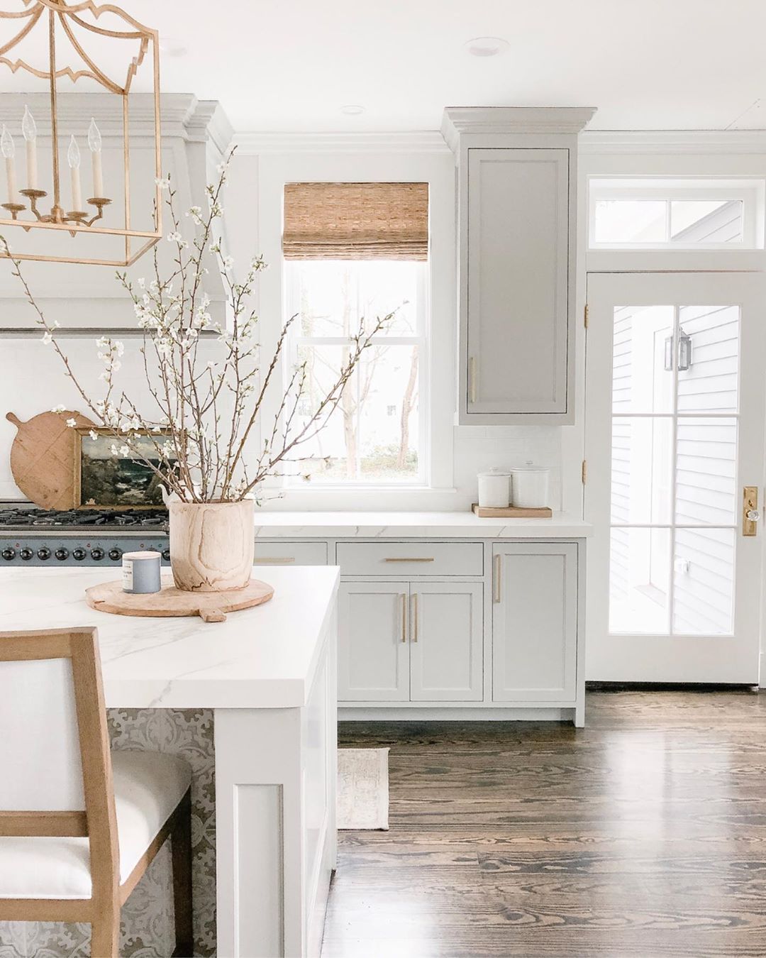 Elegant white farmhouse kitchen with Benjamin Moore Repose Grey cabinets, subway tile, gold accents, and reclaimed barn wood. Design: Finding Lovely. Wall color: Benjamin Moore Chantilly Lace.