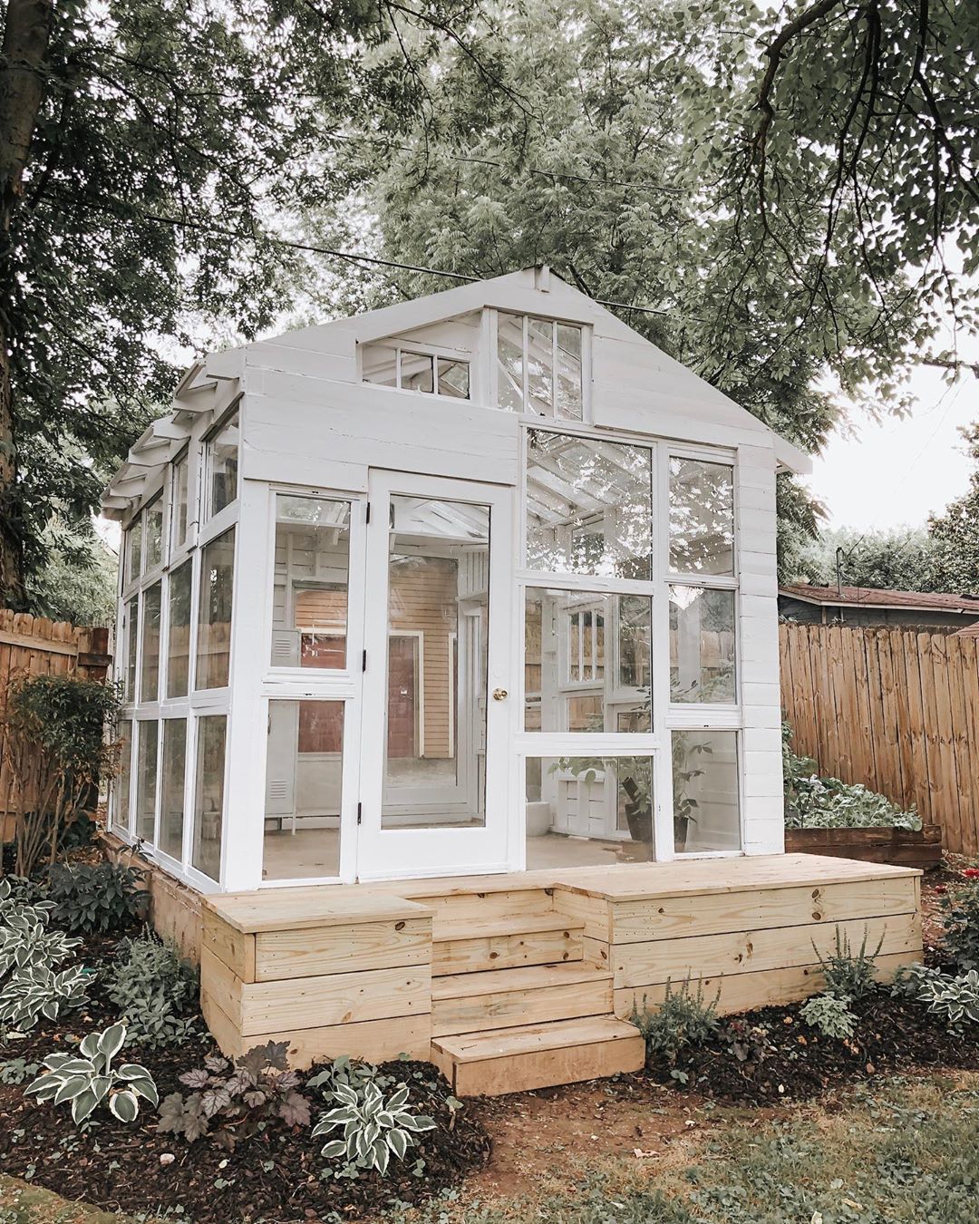 Backyard greenhouse made from vintage windows. Come explore She Shed Chic, Potting Shed & Backyard Inspiration.