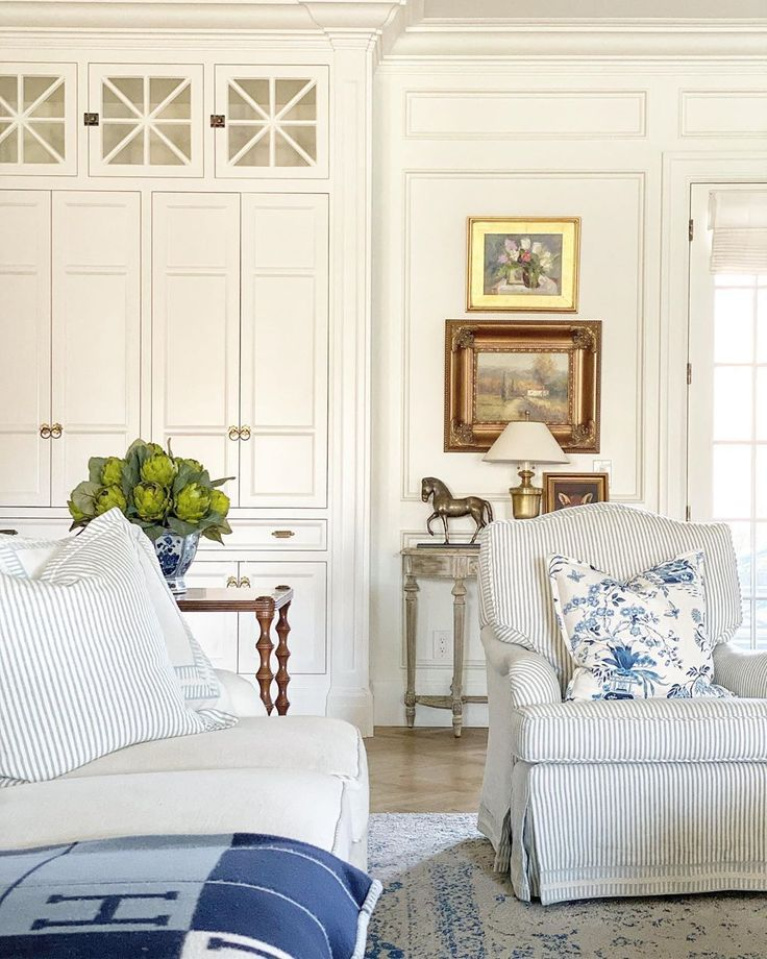 Blue accents in a gorgeous white keeping room near the kitchen by The Fox Group. #thefoxgroup #interiordesign #blueandwhite #keepingroom #livingrooms #traditionalstyle #classicdesign