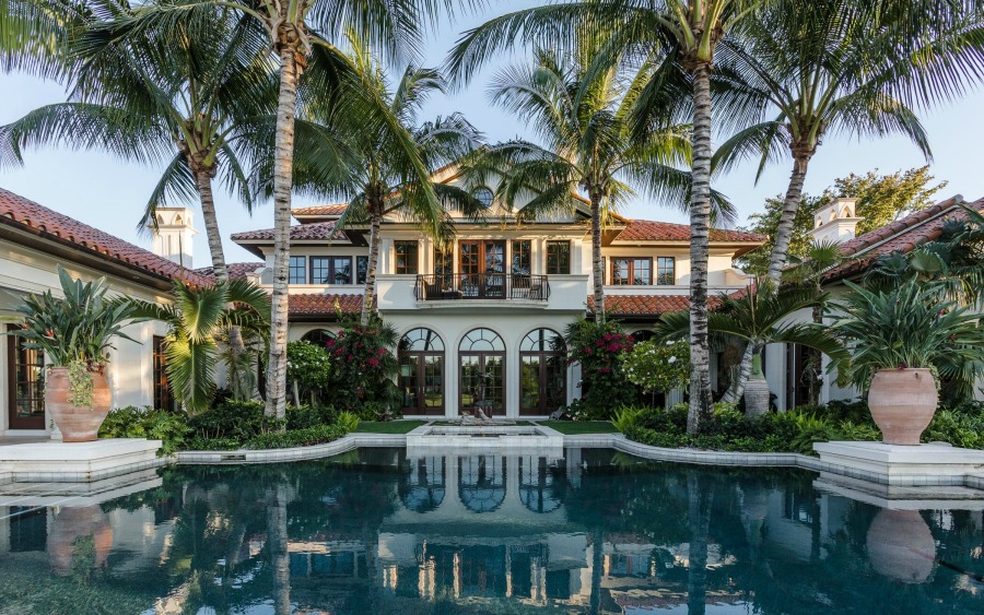 Luxurious and tropical home exterior with magnificent pool and design by Tom Stringer on Hello Lovely Studio.