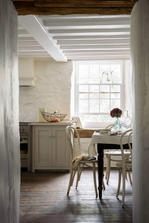 Beautifully rustic English country kitchen in the UK by deVOL has Shaker style cabinetry, farm sink, and a serene palette. 