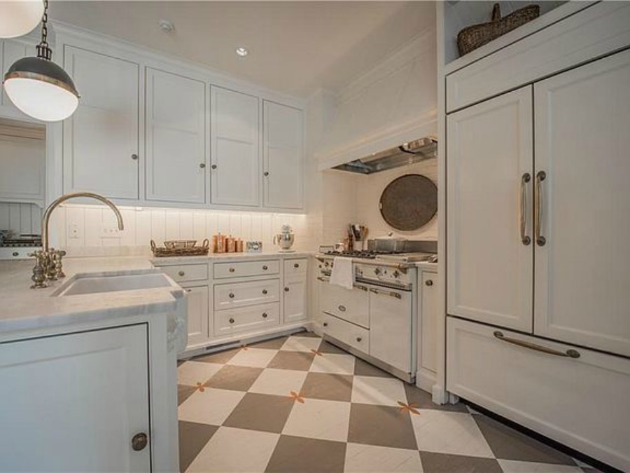 Checkered wood floor and white Lacanche range in beautiful French country kitchen of an elegant historic home with Old World style and beautifully classic European inspired interiors in Marietta Georgia was built for the Kennedy-DuPre family. ee more of the Entry, Living Room & Kitchen Design Inspiration As Well As Photos of a Beautiful Georgia Tudor Exterior on Hello Lovely Studio.