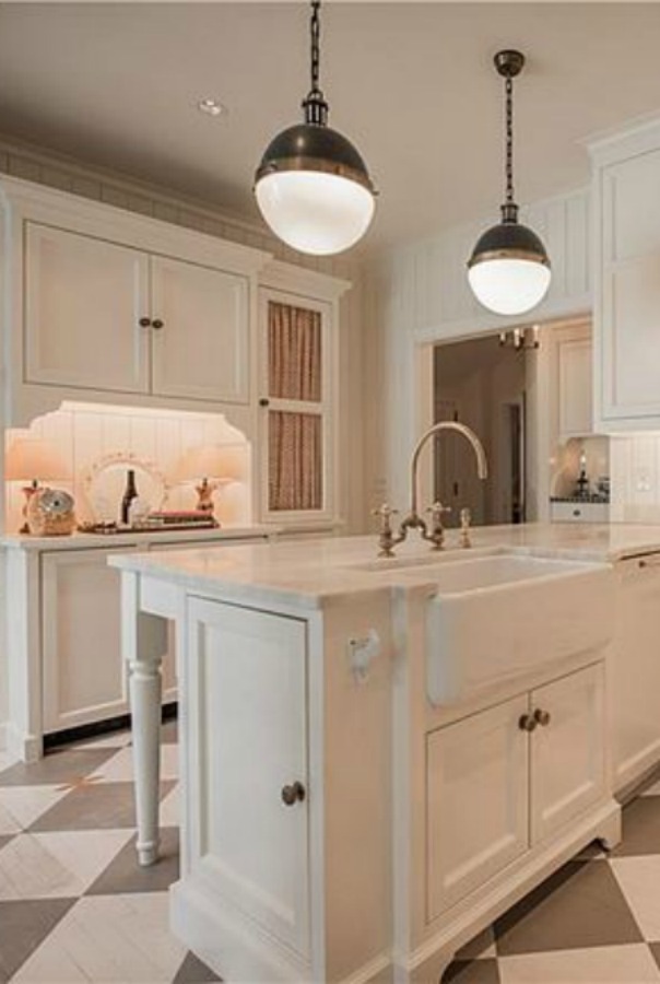 Classic white French kitchen with checkered wood floor in an elegant historic home with Old World style and beautifully classic European inspired interiors in Marietta Georgia was built for the Kennedy-DuPre family. ee more of the Entry, Living Room & Kitchen Design Inspiration As Well As Photos of a Beautiful Georgia Tudor Exterior on Hello Lovely Studio.