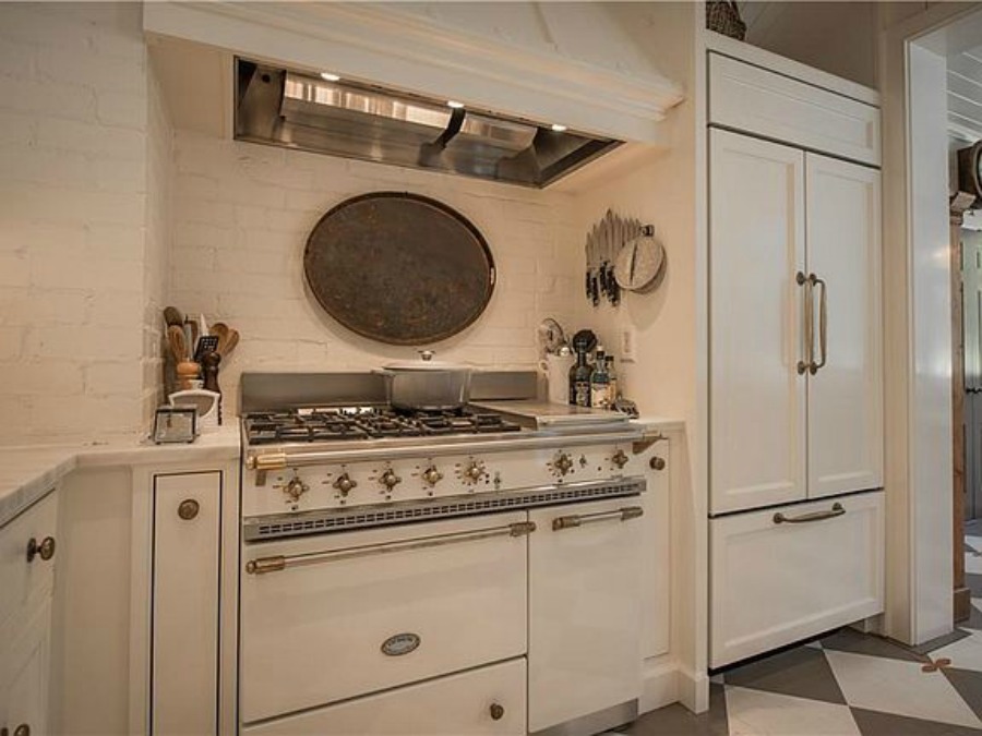 White Lacanche range in kitchen of an elegant historic home with Old World style and beautifully classic European inspired interiors in Marietta Georgia was built for the Kennedy-DuPre family. ee more of the Entry, Living Room & Kitchen Design Inspiration As Well As Photos of a Beautiful Georgia Tudor Exterior on Hello Lovely Studio.