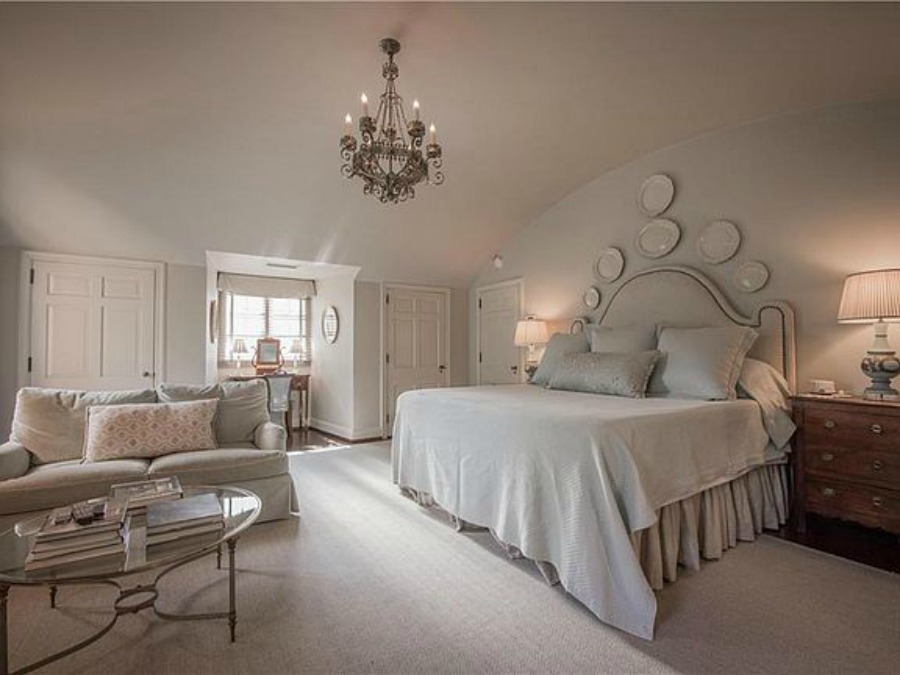 Serene French country bedroom with plates on wall in an elegant historic home with Old World style and beautifully classic European inspired interiors in Marietta Georgia was built for the Kennedy-DuPre family. See more  English Tudor Interior Design Inspiration from this European Country Master Suite & Dining Room Design Inspiration on Hello Lovely Studio.