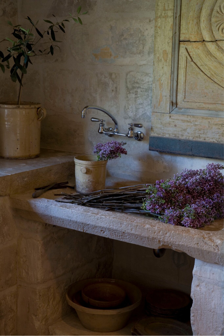 Stone sink. Exquisite reclaimed stone and architectural elements from Europe mix with antiques in a breathtaking room at founder of Chateau Domingue, Ruth Gay's home. #frenchfarmhouse #europeancountry #antiques #chateaudomingue