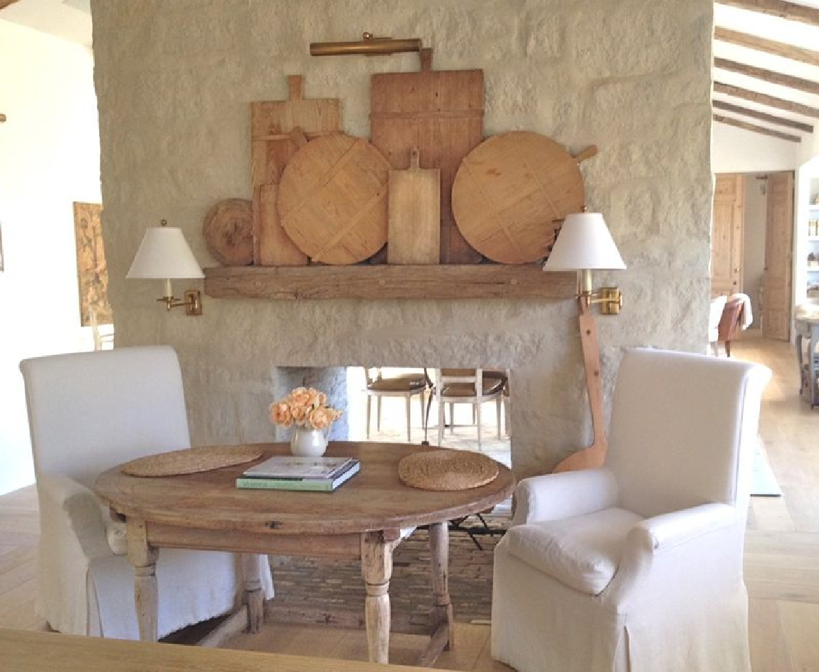 Antique cutting boards and French inspired farmhouse style in the limestone clad kitchen of Patina Farm - Brooke Giannetti. #patinafarm #kitchen #frenchfarmhouse #europeancountry #fireplace #breadboards #antiques #limestone