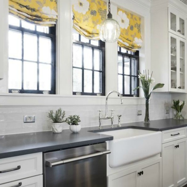 Beautiful renovated white classic kitchen in Julian Price Mansion with subway tile, farm sink, and yellow accents. Marsh Kitchens executed the lovely design which features black windows, warm wood floors, butcher block insert in huge island, and luxury range and hood.