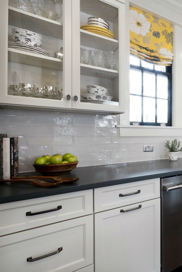 Beautiful renovated white classic kitchen in Julian Price Mansion with subway tile, farm sink, and yellow accents. Marsh Kitchens executed the lovely design which features black windows, warm wood floors, butcher block insert in huge island, and luxury range and hood.